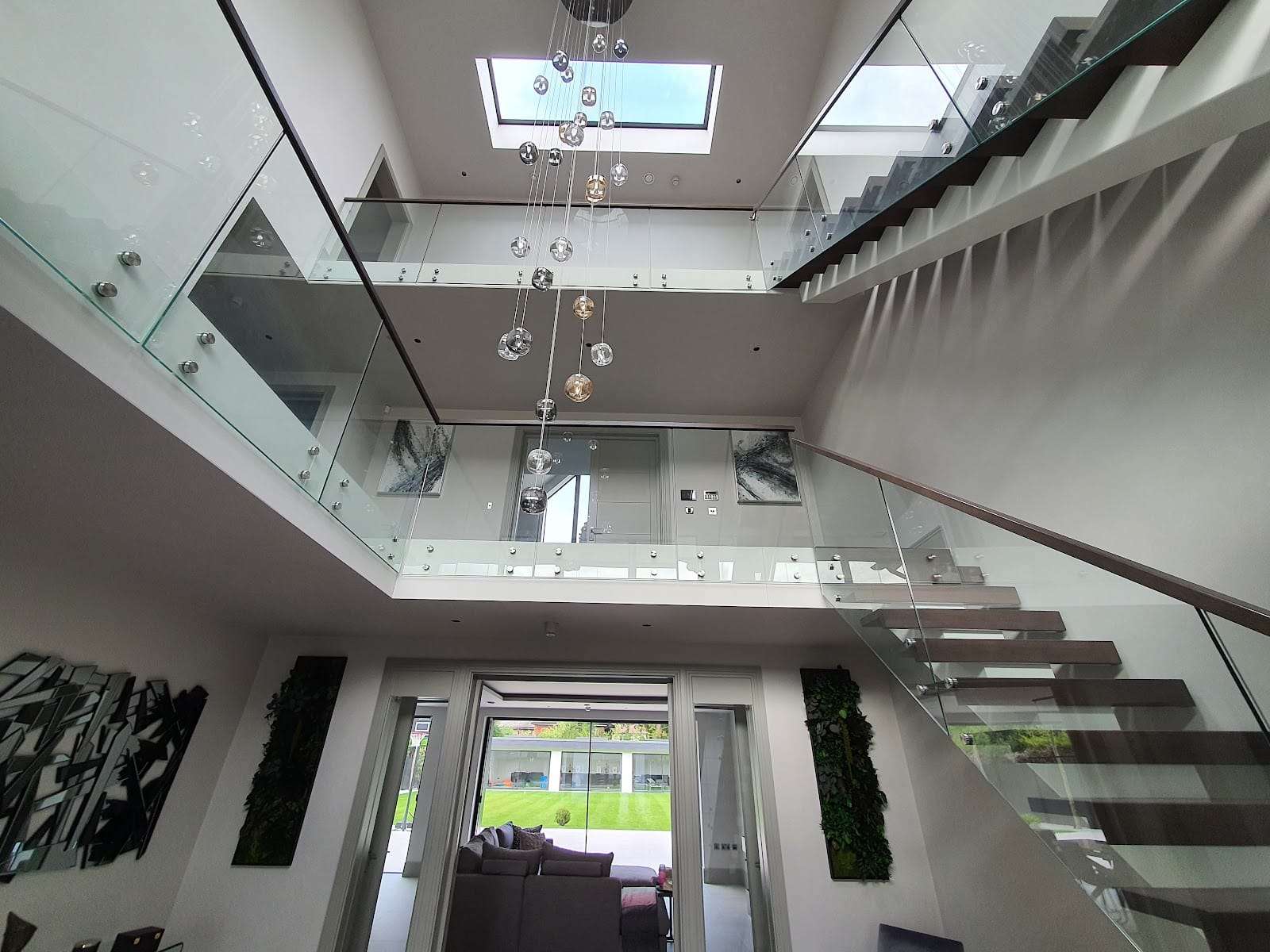 Atrium with floating glass staircase, by Briland Demja